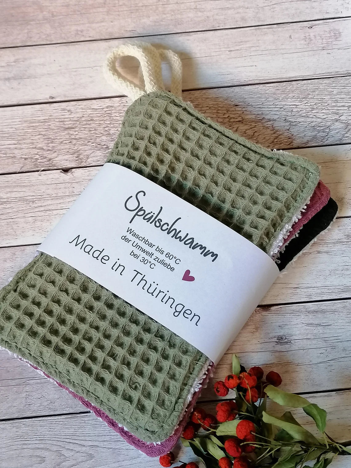  grün, blau  und rosafarbene Spültücher mit Waffelstruktur und die Rückseite ist Frottee zum aufhängen ein kleine Kordel . Die Spültücher haben ein weißes Etikett mit der Aufschrift "Spülschwamm Waschbar bis 60°C der Umwelt zuliebe bei 30°C Made in Thüringen".